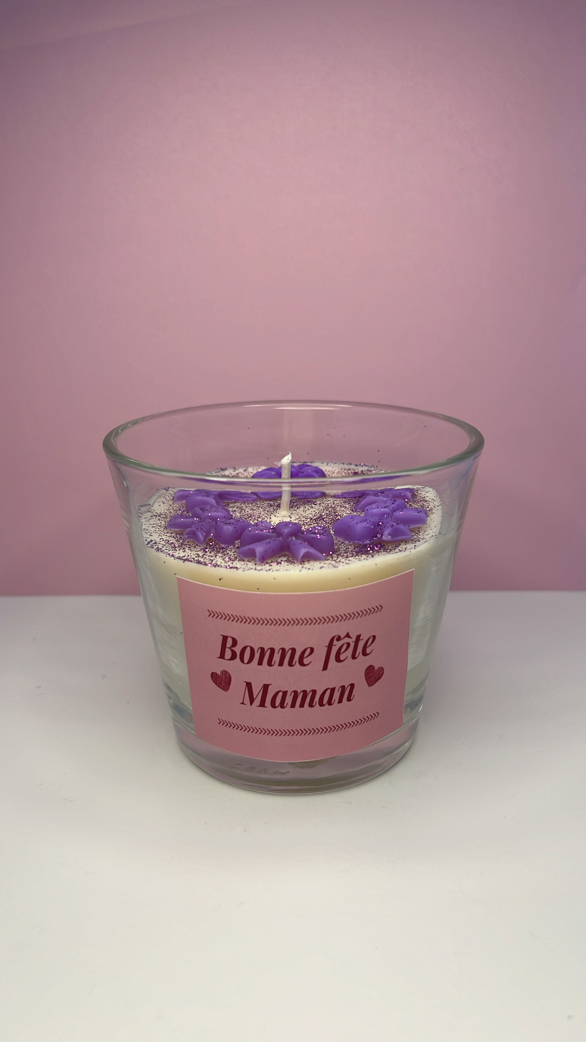 Bougie blanche avec petits noeuds violets et paillettes