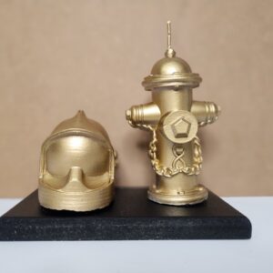 Bougie borne à incendie doré et son casque de pompier doré