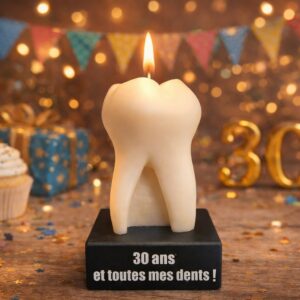 Bougie anniversaire originale en forme de dent allumée avec inscription "30 ans et toutes mes dents" sur fond festif