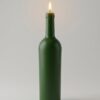 Grande bougie artisanale (23 cm) réplique exacte d'une demi-bouteille de Bordeaux (verte) allumée sur fond neutre épuré.