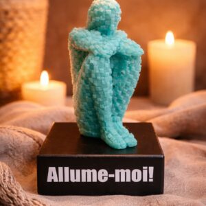 Bougie décorative bleue en forme de personnage pixel assis avec flamme allumée, ambiance chaleureuse