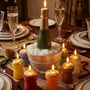 Bougie bouteille de champagne dans un seau à glace entourée de bougies en forme de bouchons colorés et allumés sur une table dressée.