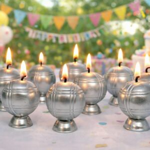 Bougies pétanque effet métal allumées sur table avec décor d’anniversaire festif
